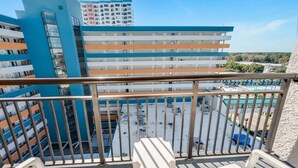 A balcony with white chairs and a view of a multi-story building with balconies. - New Landmark Resort Great Pools with Waterpark View (Myrtle Beach)