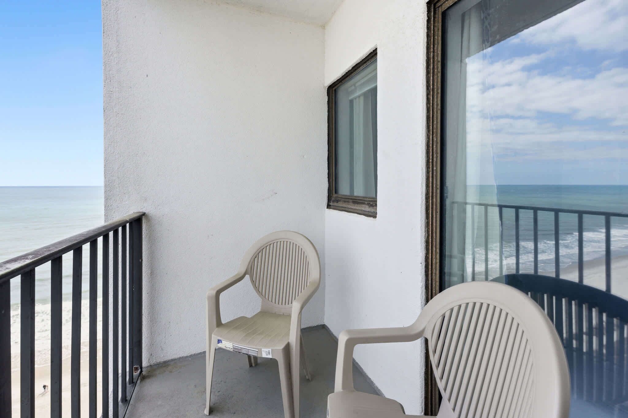 Ein Balkon mit Meerblick, einem Stuhl und einem Fenster.