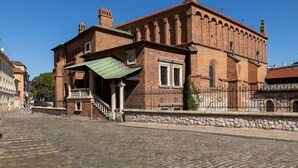 A historic building with a brick facade, a green awning, and a stone base. - Air-conditioned apartment in Kazimierz | Parking | Workplace (Kraków)