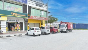 Un hôtel dont la devanture abrite un magasin 99 Speedmart et un restaurant Man Ayam Kampung.