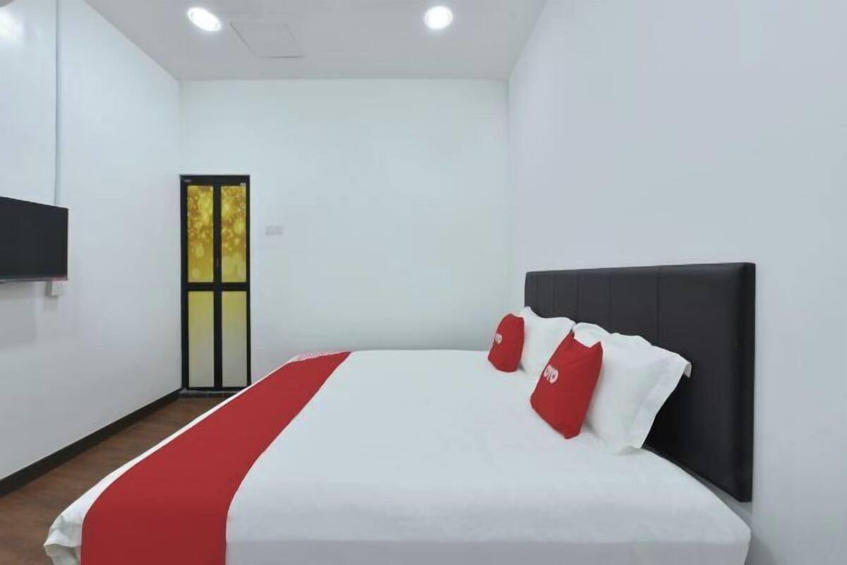 Una habitación de hotel con una cama, un televisor y una puerta con un diseño amarillo y negro.