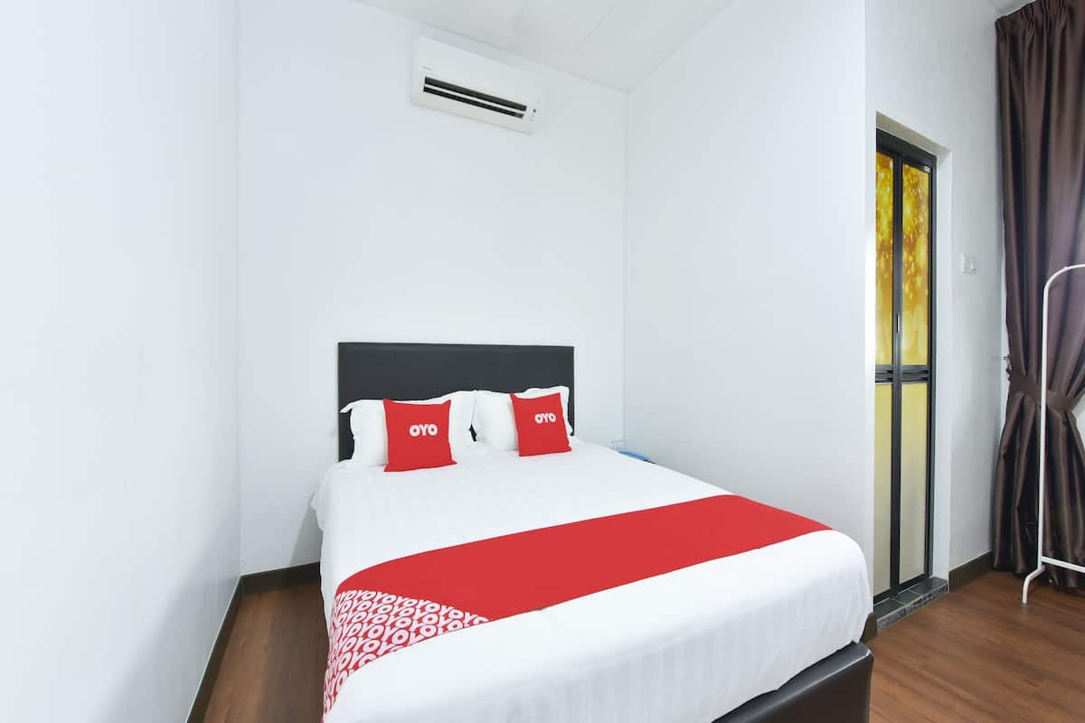 Habitación de hotel con cama, paredes blancas, ventana con cortinas y un respiradero en el techo.