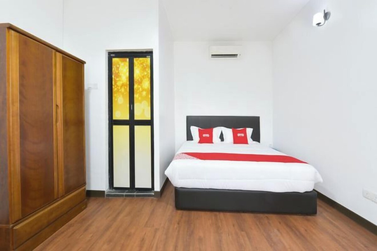 A bedroom with a bed, a wardrobe, and a door with a view.