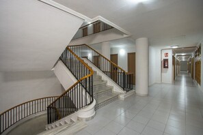 Stairs connect multiple levels in this well-maintained space with a central staircase and doors leading to various rooms.