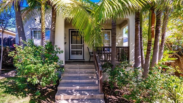 A house with a front porch, palm trees, and a staircase leading to the entrance. - North Park Haven Summ (San Diego)