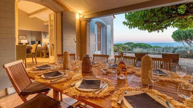 Un comedor con una mesa dispuesta para seis personas, vistas al exterior y un ambiente acogedor.