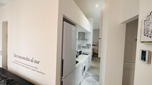 Eine moderne Küche mit Kühlschrank, Mikrowelle und Waschmaschine.