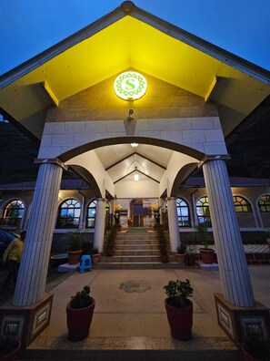 A building with a yellow roof and a circular sign with a letter 'S' on it. - Shivraj Palace Resort (Mangaon)