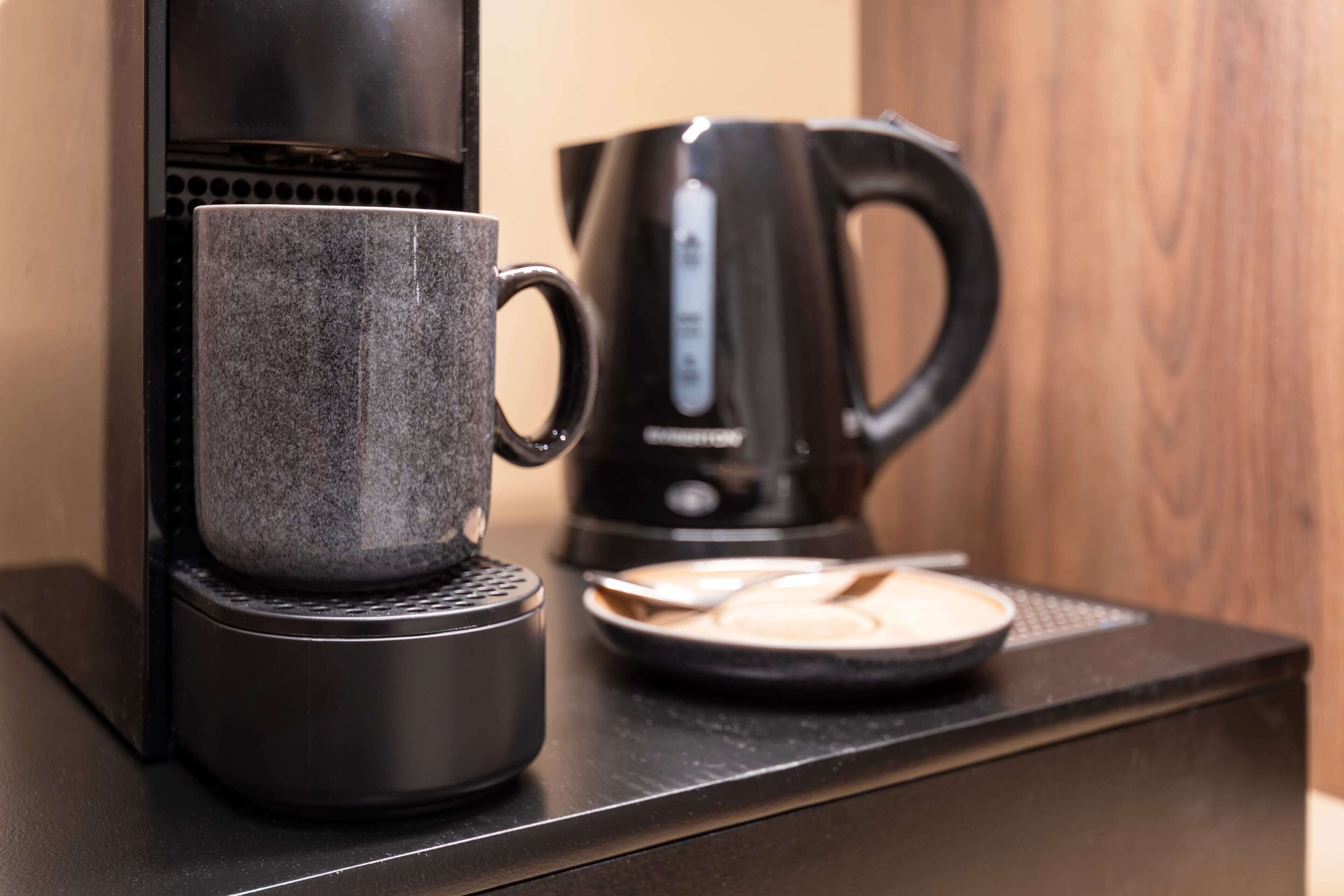 A coffee maker and a mug on a countertop.