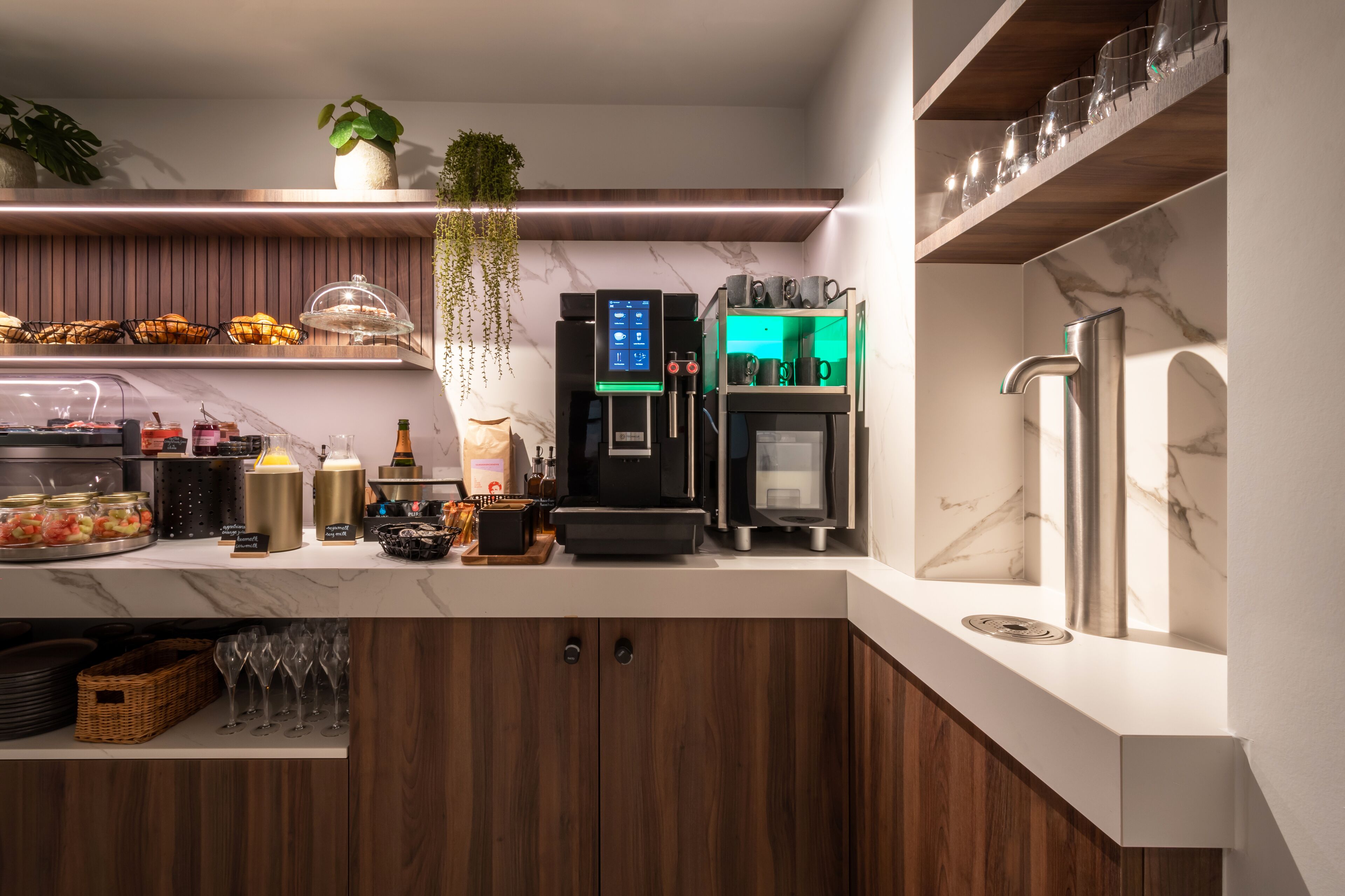 Een moderne keuken met een koffieapparaat, een koelkast en een spoelbak.