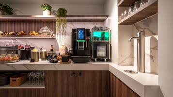Een moderne keuken met een koffieapparaat, een koelkast en een spoelbak.
