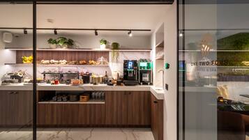 A modern kitchen with marble countertops, wooden cabinets, and a coffee machine.