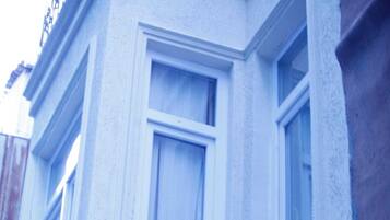 Welcome to NACRE 360 SUIT, a stylish building with a distinctive sign and elegant window details.