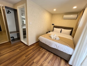 Habitación de hotel con cama, armario, baño y aire acondicionado.