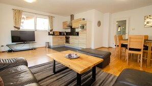 A modern apartment with a kitchen, dining area, and living room. - Kitz Residenz Six in Kaprun (Kaprun)