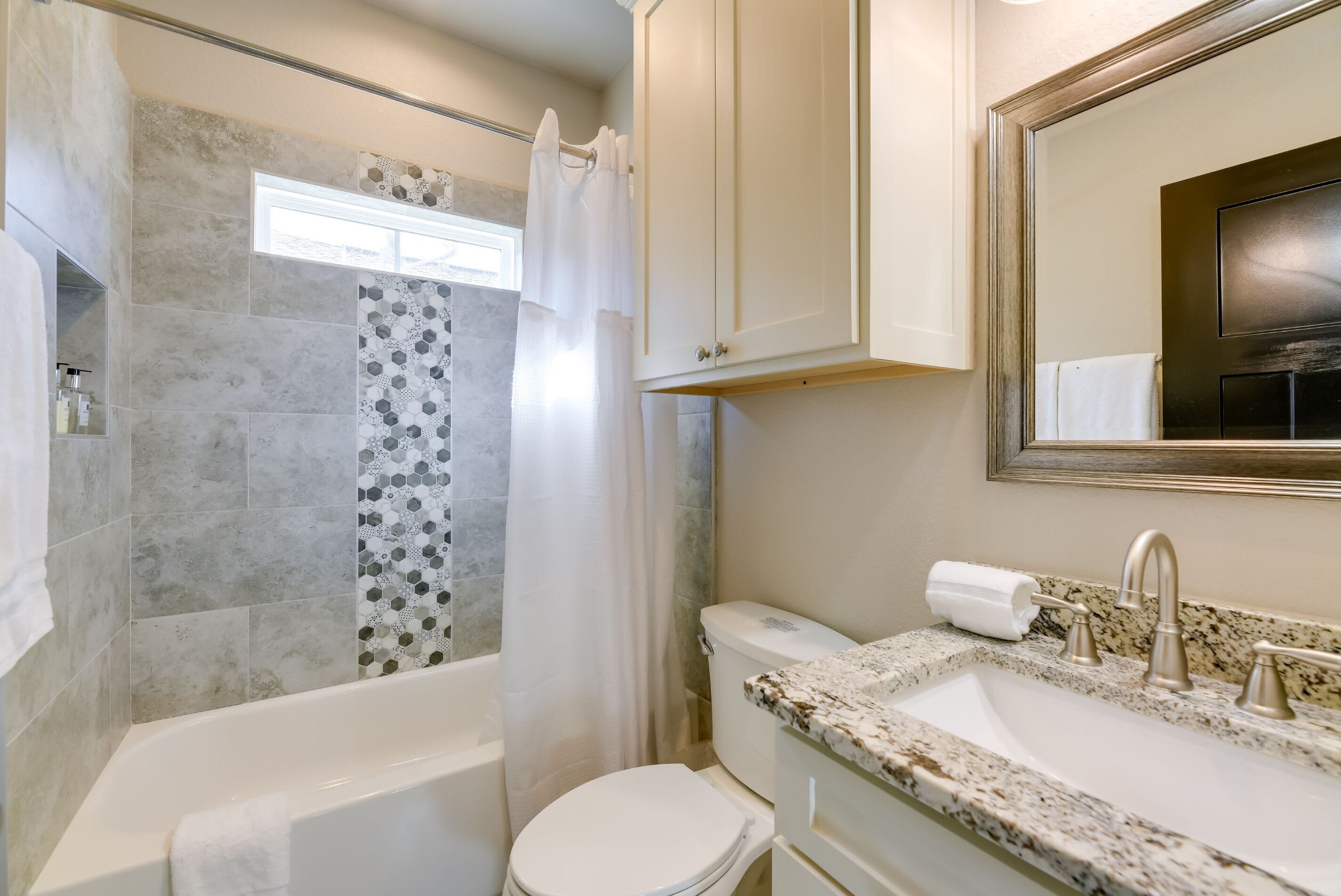 A bathroom with a bathtub, toilet, and sink.