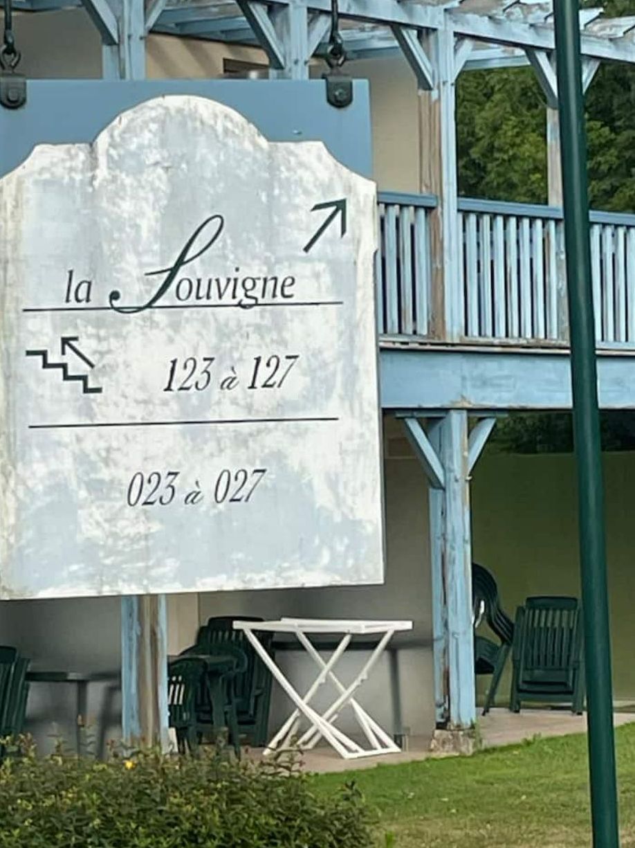 A sign with directional arrows and numbers, indicating room numbers 123 to 127 and 023 to 027.