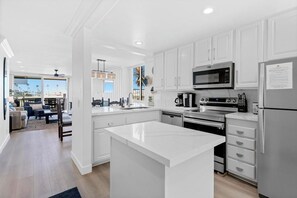 Una cocina moderna con armarios blancos, electrodomésticos de acero inoxidable y una isla grande.