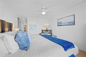 A bedroom with a bed, a ceiling fan, a nightstand with a lamp, and a painting on the wall. - Harbor Cottage North Coast Village G36-Ocean Views-*Super Close To Beach* (Oceanside)