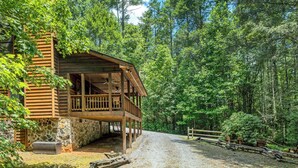 A rustic cabin with a stone foundation, wooden deck, and a gravel driveway. - SECLUDED♤Bonfire pit♤2 bdrm/2bath♤Pet friendly (Townsend)