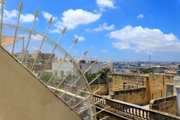 A rooftop with a metal fence and a view of the cityscape. - Stylish Valletta 2 bedroom City Centre Apartment with Terrace and Views (Valletta)