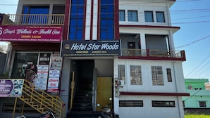 A multi-story building with a sign for Hotel Star Woods, indicating it offers luxury rooms and banquet hall services. - Hotel Starwood (Lansdowne)