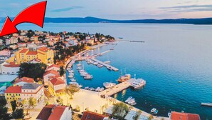 A coastal town with a marina, buildings with red roofs, and a clear view of the sea. - Holiday apartment with terrace and air conditioning (Selce)