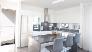 A modern kitchen with a central island, stainless steel appliances, and a view to the outside. - Villa Aria, Luxury 3BDR Protaras Villa with Private Pool, Close to the Beach (Protaras)