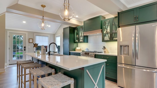 A modern kitchen with a central island, stainless steel appliances, and green cabinetry. - Cherry Pie Abode | Walkable to Downtown Boyne | Pet Friendly | Hot Tub (Boyne City)