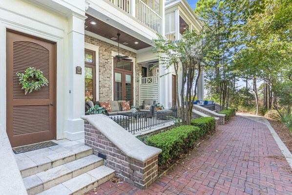 A brick house with a front porch, steps, and a mailbox.