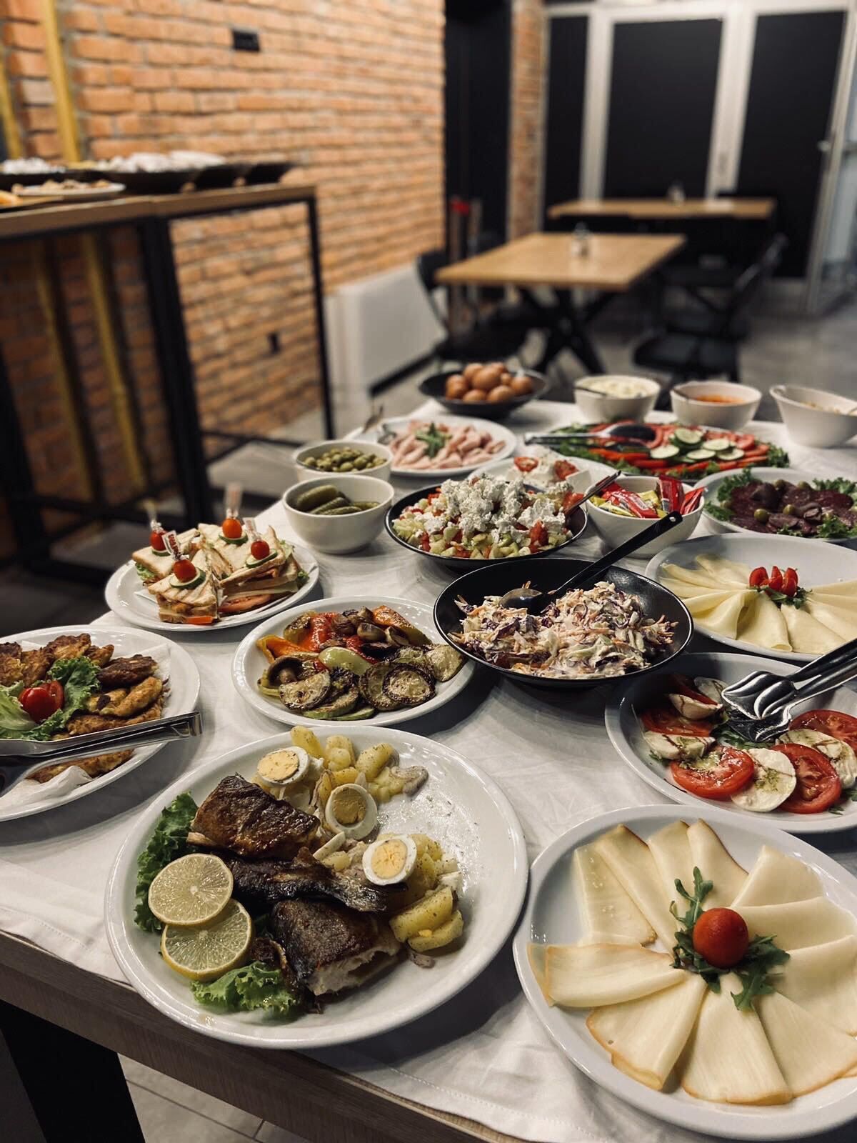 Una mesa de buffet con diversos platos, como ensaladas, carnes y pastas.