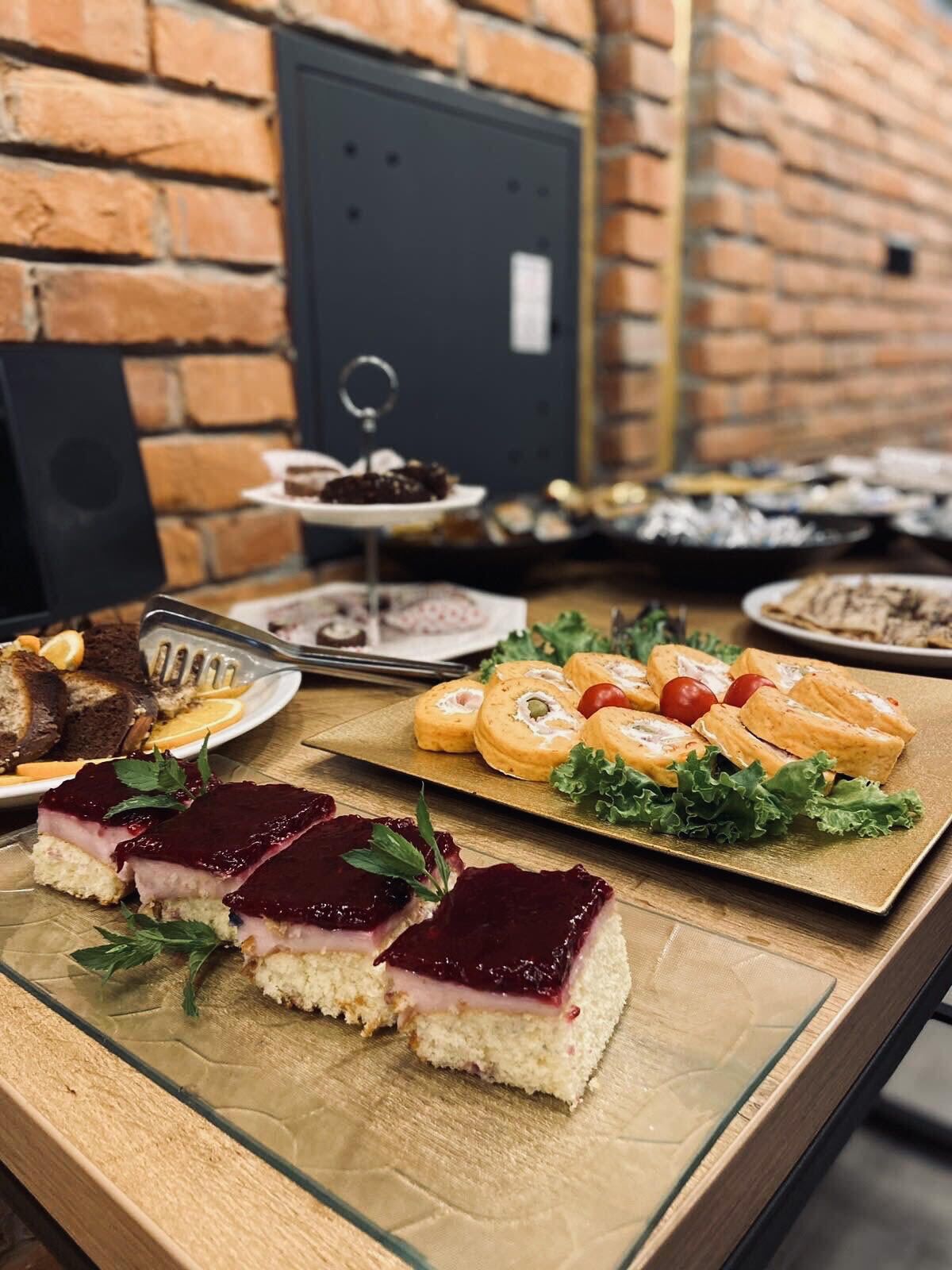 Ein Buffet mit verschiedenen Speisen, darunter Sandwiches, Gebäck und eine Torte.