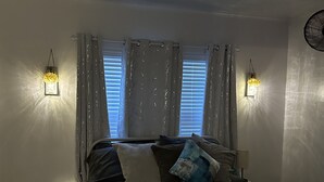 A bedroom with a bed, two wall-mounted lights, a window with blinds, and a ceiling fan. - The Walnut House - Right at OSU Greek Row and blocks from Theta Pond (Stillwater)