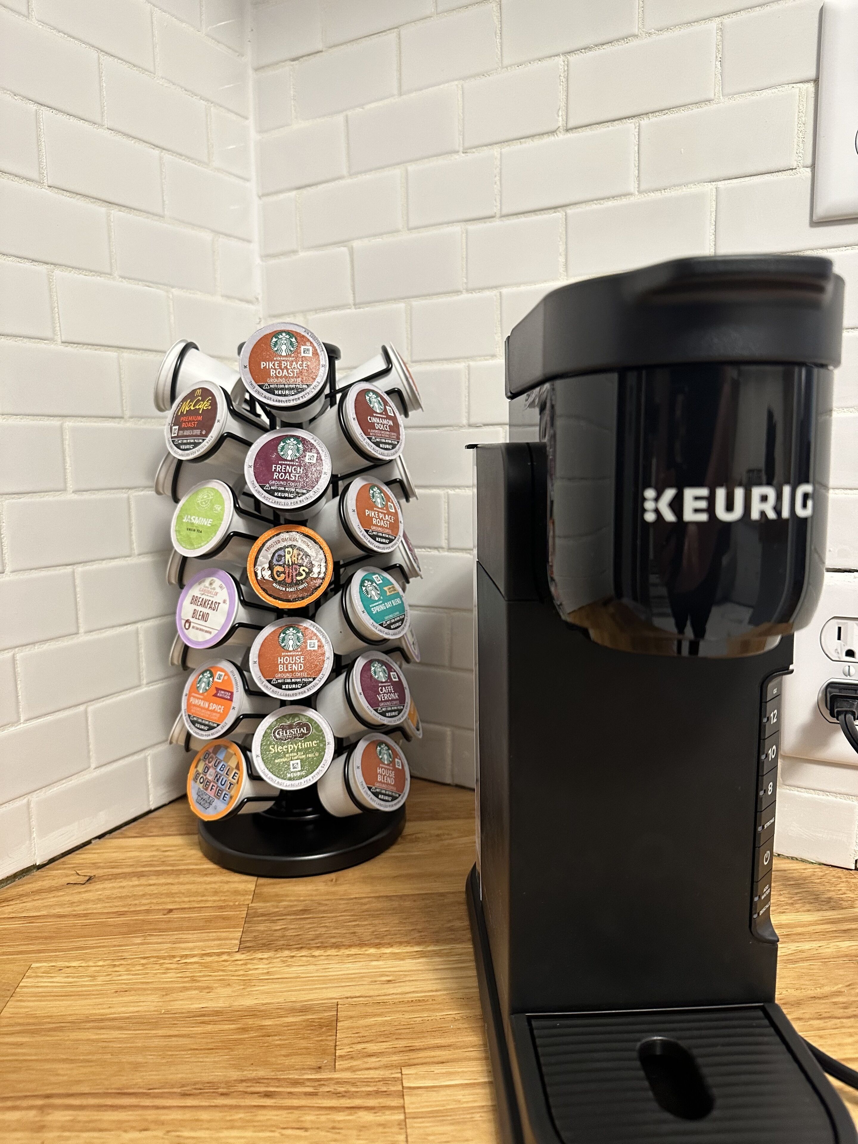 A coffee maker with a Keurig branded drip tray and a coffee pod holder with various coffee flavors.