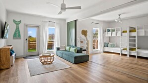 A spacious living room with a sofa, a coffee table, and a bookshelf. - Your Beach Retreat Awaits: Game Room, Community Pool & Easy Beach Access (Port Aransas)