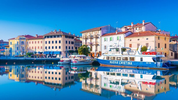 A waterfront scene with a boat named 'NUOVA CRISTINA' docked at a marina. - Beautiful Apartment Located Close to the Beach in Grado Pineta Italy (Grado)
