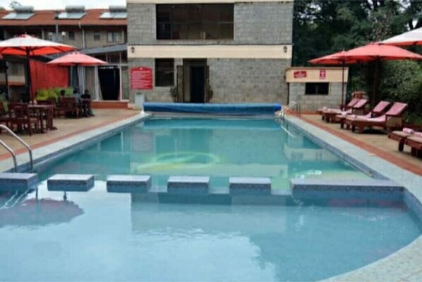 Relax by the pool surrounded by comfortable lounge chairs and shaded seating areas.