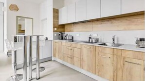 Eine moderne Küche mit weißen Schränken, einer Holz Arbeitsplatte und Edelstahlgeräten.