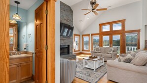 A spacious living area with a fireplace, large windows, and a ceiling fan. - New - Pool,Game Room,Access 2 Beach,Golf Community (Corolla)