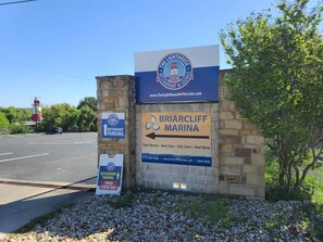 A sign for Briarcliff Marina with amenities listed, including boat rentals and a ship store.