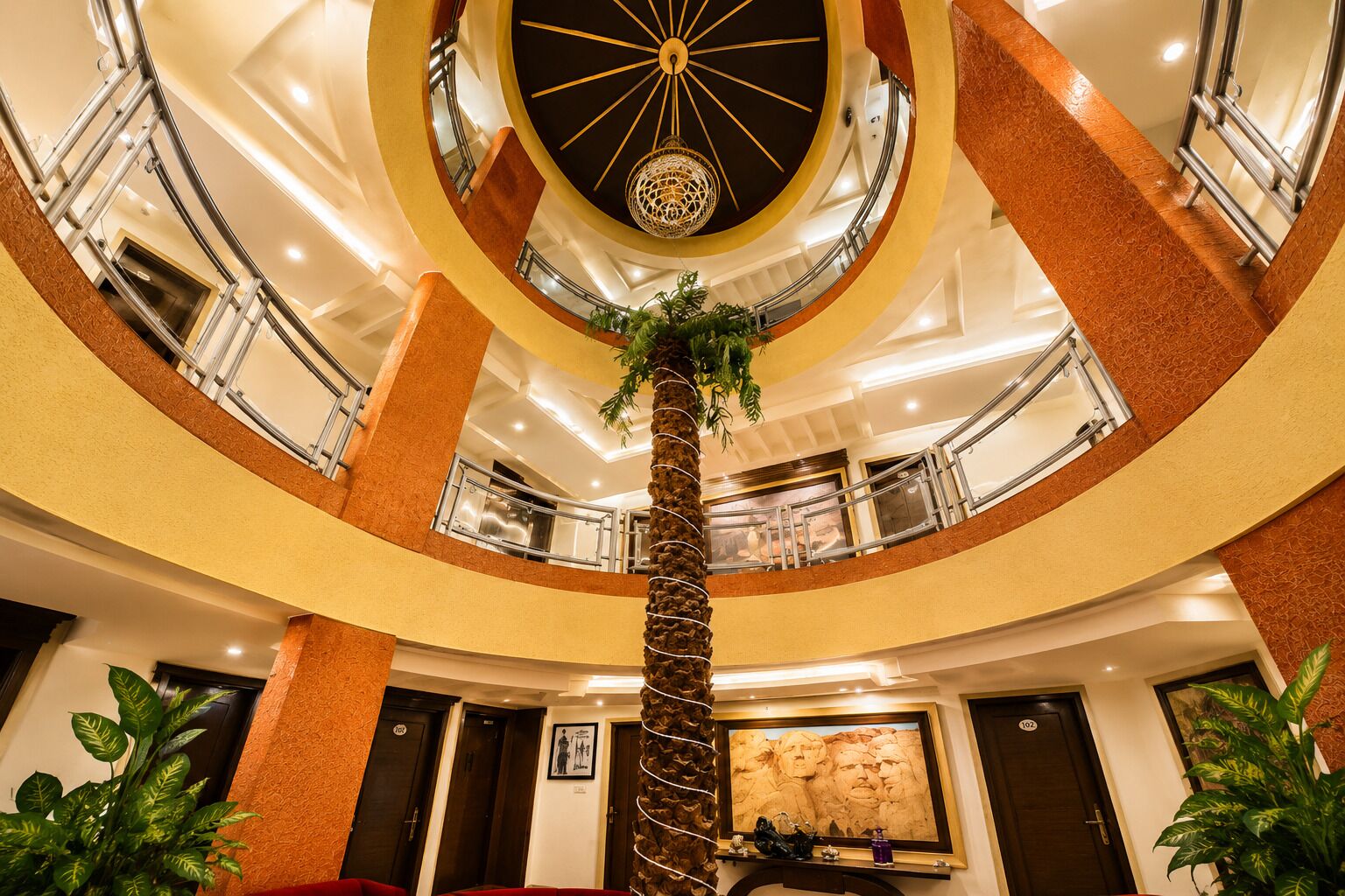 A multi-level atrium with a central spiral staircase, multiple balconies, and a large mural on the lower level.