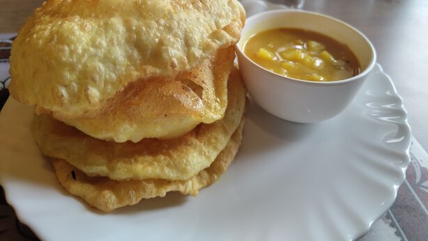 A plate with a stack of fried food and a bowl of soup. - Hotel Europa Inn (Rajkot)