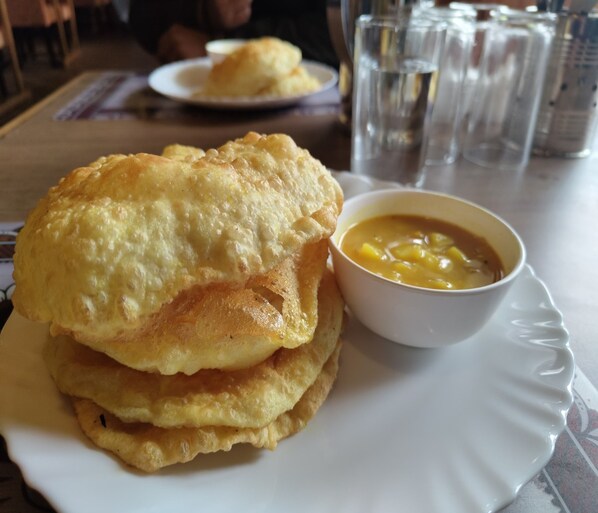 A plate with a stack of fried food and a bowl of soup.
