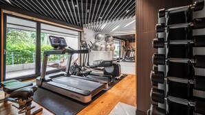 A modern gym with a treadmill, exercise balls, and weight racks. - Apartamenty Sun & Snow Rezydencja Łazienki Park (Warsaw)