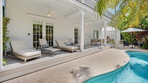 A covered outdoor area with a pool, lounge chairs, and a patio table. - **SIREN'S SERENADE @ THE ANNEX** Home & Pool + Last Key White Glove Service... (Key West)