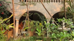 A courtyard with a covered seating area, palm trees, and a water feature. - The Gallery Boutique Hotel (Harare)