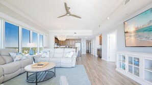 A spacious living room with a large sofa, a coffee table, and a view of the kitchen. - Condo at Phoenix Orange Beach II, Brand New! (Orange Beach)