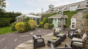 A patio area with outdoor furniture and a conservatory.