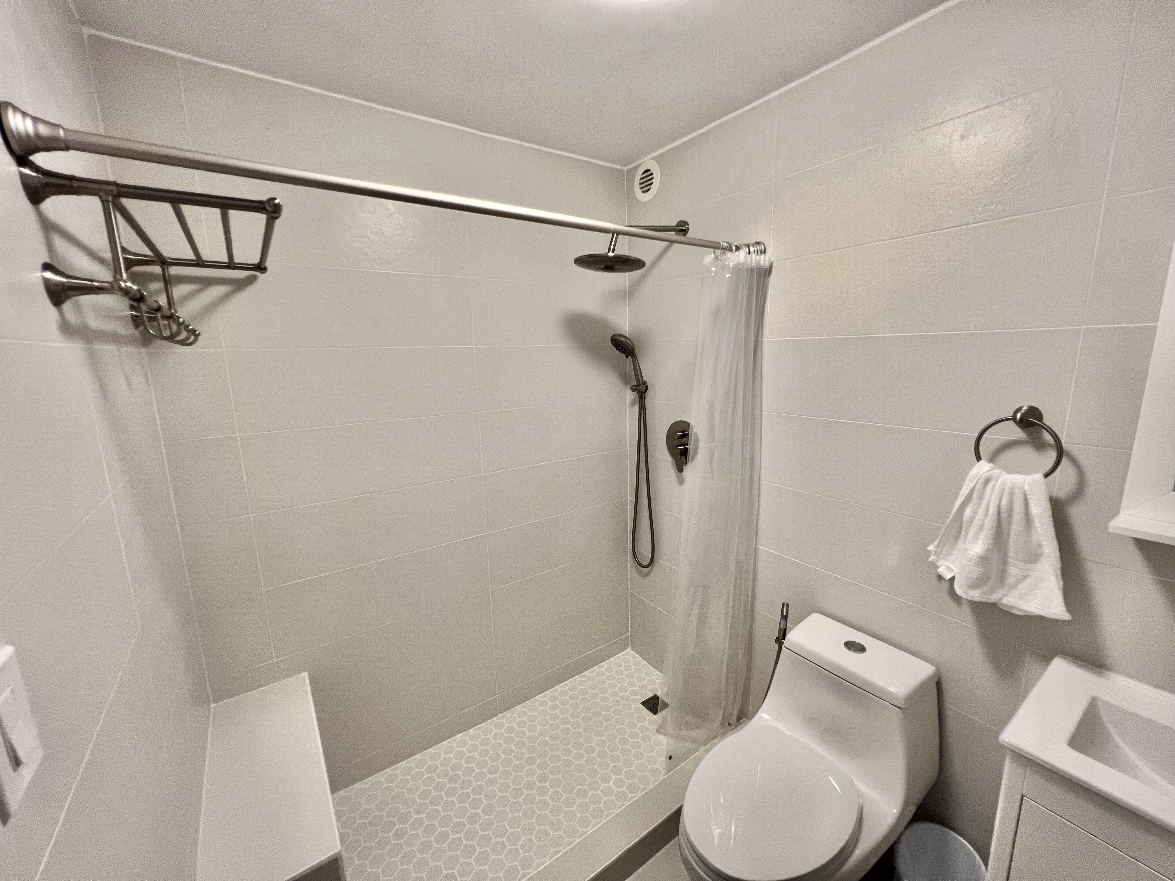 Une salle de bain moderne équipée d’une douche, de toilettes et d’un lavabo.
