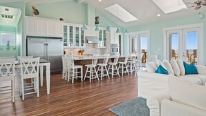 A spacious kitchen with white cabinetry, a central island, and pendant lighting.